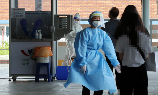 28일 오전 광주 북구보건소 선별진료소에 전날 시내버스 운전자 코로나19 확진 소식에 버스를 탔던 시민들이 한꺼번에 검사를 받기 위해 몰려들었다.   [연합뉴스]